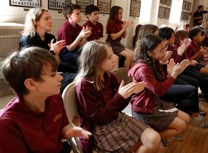 Students and a teacher clap during the presentation. (Karen Callaway/Chicago Catholic)