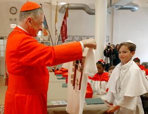 Cardinal Cupich holds up a T-shirt from the students and given to him by “Pope” Auggie Wilk. The cardinal told the students he would give the T-shirt to Pope Leo XIV. (Karen Callaway/Chicago Catholic)