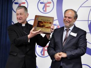 Chicago Archbishop Blase Cupich receives a gift from Halil Demir, executive director of the Zakat Foundation of America during the19th Annual Catholic-Muslim iftar dinner in Bridgeview on June 27. (Karen Callaway/Catholic New World)