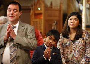 John, John (9), and Cecile Brehm pray during the Mass. (Karen Callaway/Catholic New World)