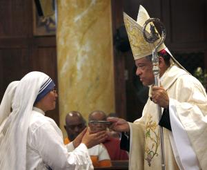 Bishop Joseph Perry accepts the gifts from Missionary of Charity sisters during a Mass on Sept. 5 celebrating the feast of St. Teresa of Kolkata at St. Malachy Church, 2248 W. Washington Blvd. (Karen Callaway/Catholic New World)