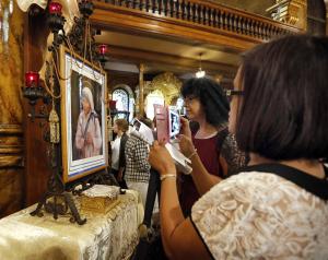 Worshippers stop after Mass to take pictures of a portrait of Mother Teresa. (Karen Callaway/Catholic New World)