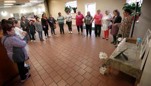 Doris Hernandez, co-founder of Padres Angeles, leads mothers in prayer near an altar the group made with pictures of deceased family members during a Mother's Day gathering to pray for children lost to violence at St. Agnes of Bohemia Parish on May 14, 2019. (Karen Callaway/Chicago Catholic)