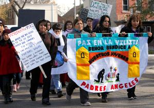 Doris Hernández and Dolores Castañeda, co-founders of Padres Angeles, hold a sign and process in an anti-violence march in celebration of Day of the Dead through Little Village on Nov. 1, 2014. (Karen Callaway/Chicago Catholic)