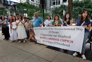 Members of The Communities of Neocatechumenal Way of Chicago sing as they hold a sign congratulating Cardinal Cupich outside the cathedral before Mass begins. (Karen Callaway/Chicago Catholic)