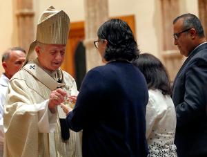 Cardinal Cupich accepts the gifts from Betsy Bohlen, chief operating officer for the Archdiocese of Chicago, and other pastoral center employees during Mass. (Karen Callaway/Chicago Catholic)