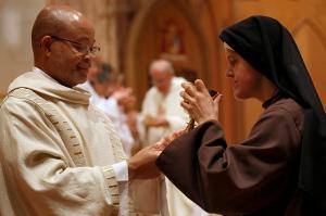 Deacon James Norman, vicar for deacons, distributes the Blood of Christ to Franciscan of the Eucharist of Chicago Sister Kate O’Leary during Communion. (Karen Callaway/Chicago Catholic)