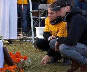 A participant becomes emotional after placing an item of remembrance near the altar during Mass. (Karen Callaway/Chicago Catholic)
