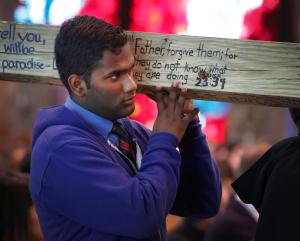 Víctor Martínez, estudiante del último año en la secundaria St. Rita of Cascia, participa en las Estaciones de la Cruz el 14 de marzo. Comenzaron en su capilla y luego procedieron hacia afuera para una marcha a lo largo de la avenida Western con avisos y cruces llamando a parar la violencia. Foto: Karen Callaway