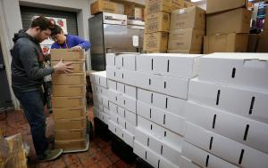 Los voluntarios José Serrano y Luciano Blanco descargan cajas llenas de alimentos. Foto: Karen Callaway/ Católico