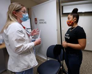 Roni Facen, directora de la secundaria St. Francis de Sales, en 10155 S Ewing Ave. en Chicago, recibe su primera dosis de la vacuna Pfizer a manos de la enfermera Kristen Tucker, en Mulcahy Center, el centro médico de la Universidad Loyola en Maywood, el 7 de marzo.
Durante la semana del 15 de febrero, la Arquidiócesis de Chicago, en asociación con los sistemas de escuelas de Agudath Israel de Illinois y del Sínodo de la Iglesia Luterana de Missouri, lanzó un plan de vacunación contra COVID-19 para todos los empleados en los tres sistemas escolares basados en la fe. Foto: Karen Callaway/Católico