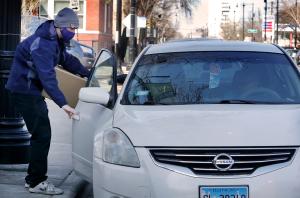 Declan Carroll ayuda a cargar cajas con comida en la despensa semanal en la parroquia St. Columbanus el 31 de marzo. La despensa ofrece alimentos cada miércoles de 10:00 a.m. a 12:00 p.m. a residentes en los códigos 60619 y 60637. Foto: Karen Callaway/Católico