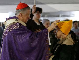 El cardenal Cupich imparte cenizas a una feligresa durante la misa.