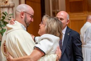 El padre John Rahimi es felicitado por su madre, Elizabeth, después de la misa. Foto: Diácono Randy Belice/Católico