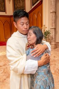 El padre Conrad Espino es felicitado por su madre, Jonabel, después de la misa. Foto: Diácono Randy Belice/Católico