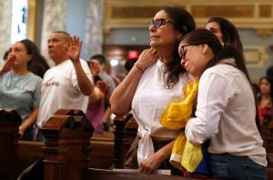 Gisela Chacón y Susan Aldana se abrazan durante la oración por el pueblo de Venezuela.