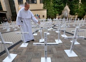 El padre dominico Brendan Curran organiza las cruces en el atrio de la Catedral el 27 de septiembre.