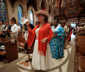 Una mujer representando a Perú recorre la procesión por el pasillo de Catedral en la misa del 27 de septiembre.