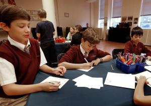 Cameron Smith, Auggie Wilk and Johan Lin hacen sus tarjetas. Ellos participaron en el simulacro de cónclave, donde Auggie fue electo papa, y sus compañeros interpretaron a cardenales.