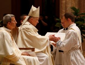 El sacerdote electo Joseph Brom promete al cardenal su 