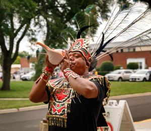 Un intérprete de danza azteca sopla una concha la entrada del santuario.  Foto: Cynthia Flores-Mocarski/Católico
