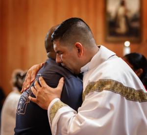 El padre Manuel Dorantes abraza a uno de los feligreses después de la unción. Foto: Cynthia Flores-Mocarski/Católico