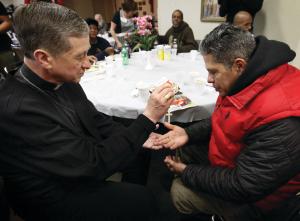 El Arzobispo Blase Cupich bendice un rosario para Jaime Dones cuando visitó a los asistentes a la cena del Día de Acción de Gracias de Caridades Católicas en el centro St. Vincent ,en 721 North LaSalle Street in Chicago el 27 de noviembre. Esta cena se organiza para la gente sin techo y con hambre. Foto: Karen Callaway/Católico