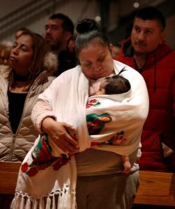 Una feligresa sostiene a su bebé durante la misa oficiada por el cardenal Cupich el 11 de diciembre. Foto: Karen Callaway/Católico