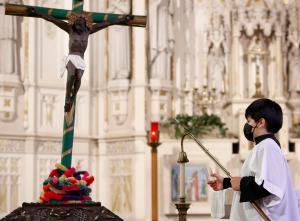 Un monaguillo apaga las velas después de la misa a Nuestro Señor de Esquipulas en San Alfonso el 15 de enero.