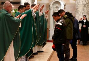 El padre nicaragüense Erick Díaz se une a los sacerdotes de la parroquia para bendecir a los refugiados en la misa del 19 de febrero.