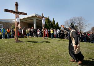Un parroquiano representando a uno de los sacerdotes grita a Jesús mientras él agoniza en la cruz.