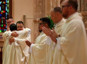 El nuevo sacerdote Francisco Javier Pagán Portalatín recibe un abrazo de felicitación después de ser investido.