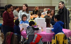 Laura Baker y su esposo Matt, con sus hijos y otras familias en el proyecto de regalos el 4 de febrero en McDonnell Hall en Glenview. Foto: Karie Angell Luc/ Católico
