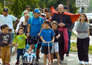 El obispo Kevin Birmingham encabeza a los migrantes hacia la misa en St. Pascal en junio de 2023. Foto: Karie Angell Luc/Católico