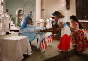 Alena Gianna Meléndez y Dalia Ríos llevan flores a Ntra. Sra. antes de ser coronada al principio de la misa. Fotos: Karen Callaway/Católico