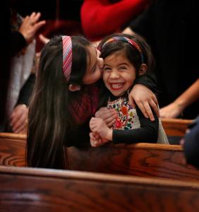 Alicia López le da a su hermana Amelia un abrazo y un beso durante el saludo de paz en la misa por el Señor de Esquipulas el 14 de enero en San Alfonso. Fotos: Karen Callaway/Católico