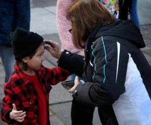 Carolina Díaz distribuye cenizas a parroquianos de Cristo Rey y residentes de la comunidad en la plaza memorial Manuel Pérez Jr. en La Villita, el 14 de febrero.