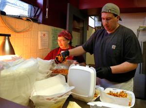 Nancy Werner y Dan Cortes preparan órdenes para llevar, mientras voluntarios trabajan durante la venta de pescado frito en la parroquia St. John Neumann en Homewood, el 16 de febrero.