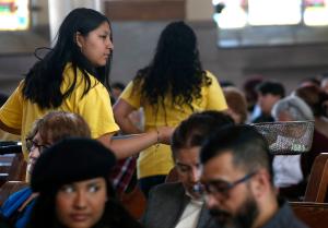 Sandra Manuel recoge la limosna durante la colecta en la misa del 21 de abril en Inmaculada Concepción-San Miguel, en Sur Chicago.