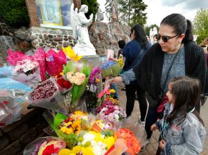 La alumna de preprimaria Maritza Mayorga y su abuela Diana Martínez depositan flores ante la imagen de Ntra. Sra. de Guadalupe.