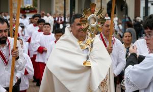 El padre José Sequeira, rector asociado del Santuario, lleva la custodia durante el evento el 27 de junio.