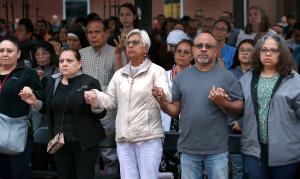 Feligreses oran el Padre Nuestro durante la misa en el Santuario de Des Plaines.