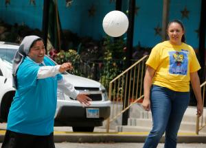 La hermana Claudia Patricia Sanchez, maestra de 5to grado en la escuela Inmaculada Concepción devuelve el balón durante un juego de volleyball con los jóvenes el 20 de julio.