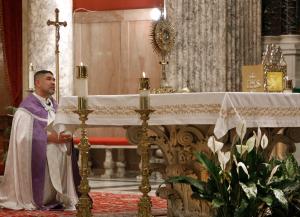 El padre Manuel Dorantes ora ante el ostensorio durante el servicio.