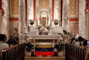 El padre Dorantes levanta el ostensorio ante los feligreses que asistieron a orar por la paz en Venezuela.