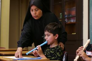 La hermana Mirna enseña la flauta dulce a Rigoberto Berrios en la clase de música.