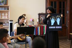 La hermana Francisca Solano enseña guitarra a Lucas Juan y al resto del grupo.