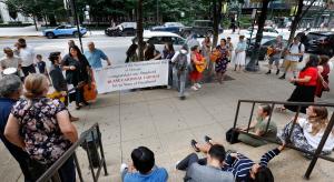 Miembros de las Comunidades de Neocatechumenal Way de Chicago cantan y sostienen una manta para felicitar al cardenal Cupich fuera de la catedral antes de misa.