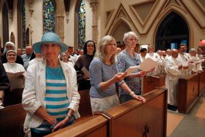 Miembros de la congregación escuchan al cardenal antes de la bendición de despedida.