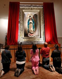 Feligreses oran ante la escultura de la Virgen en la capilla. Foto: Karen Callaway/Católico